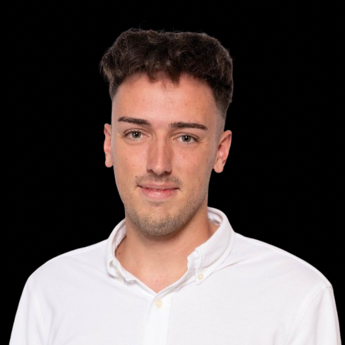 Junger Mann mit kurzen Haaren, trägt ein weißes Hemd, neutraler Hintergrund.